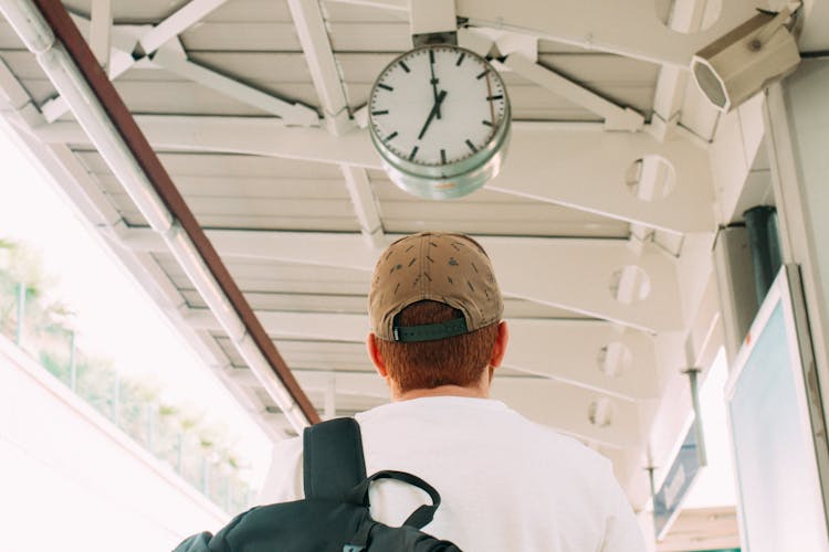 Man Looking At A Clock On A Platform 