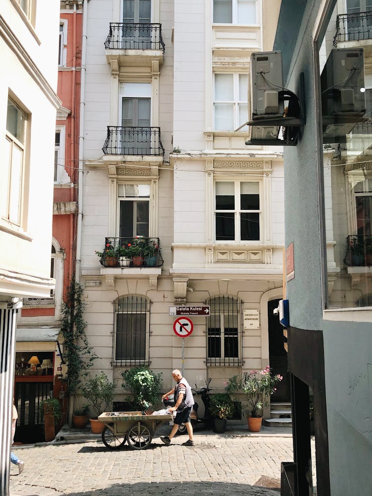 Man Pushing A Cart On The Street