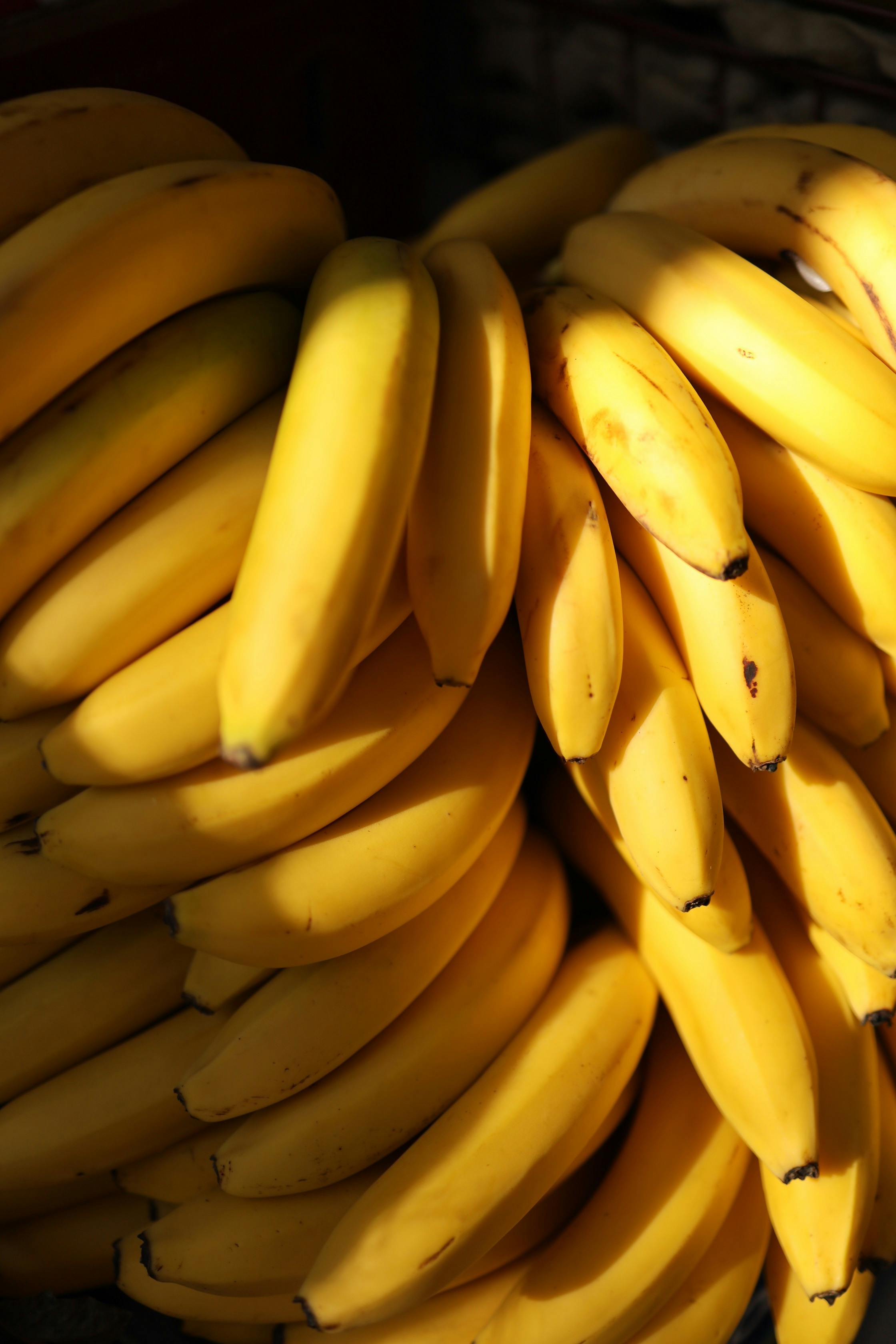 A detailed view of a bunch of fresh yellow bananas, showcasing their texture and vibrancy.