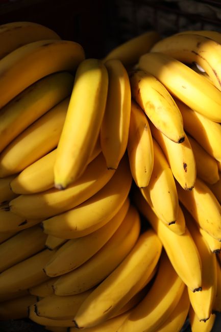 A detailed view of a bunch of fresh yellow bananas, showcasing their texture and vibrancy.