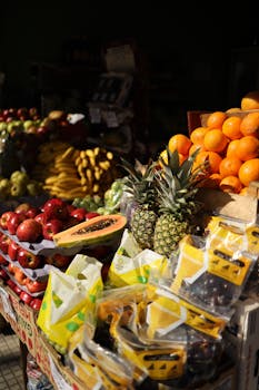Colorful display of fresh tropical fruits at a bustling street market, perfect for food enthusiasts.