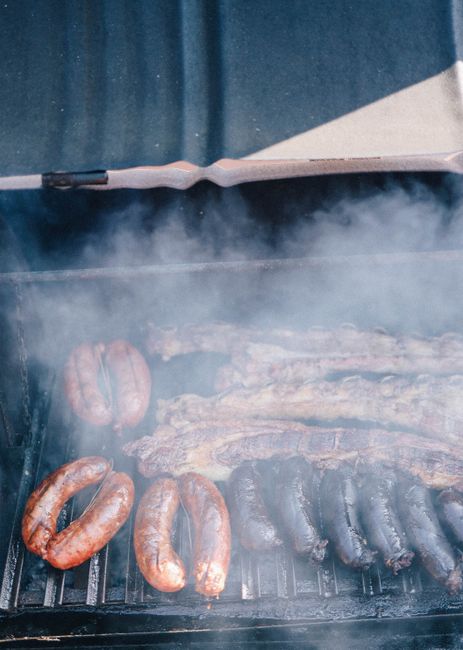 Fotomural Close-up de carnes y salchichas variadas asándose con calor ahumado en una parrilla.