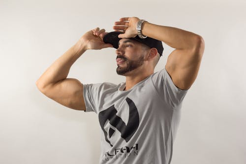 A Man in Grey Crew Neck T-shirt Touching His Black Cap