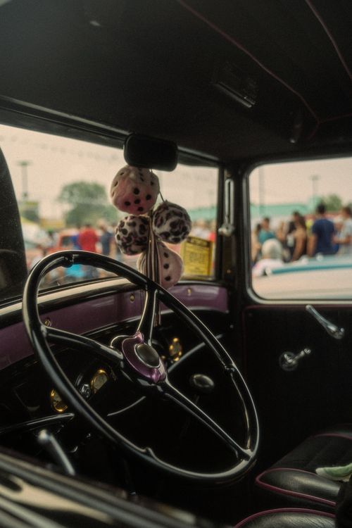 Free Close-up of a classic car steering wheel with fuzzy dice, capturing the nostalgic feel of a Reno car show. Stock Photo