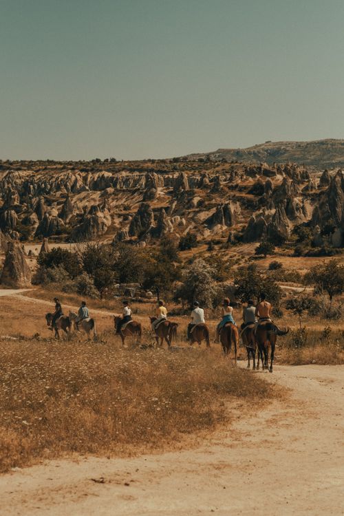 Free Explore a group of riders on horseback journeying through the captivating rocky terrain of Cappadocia. Stock Photo
