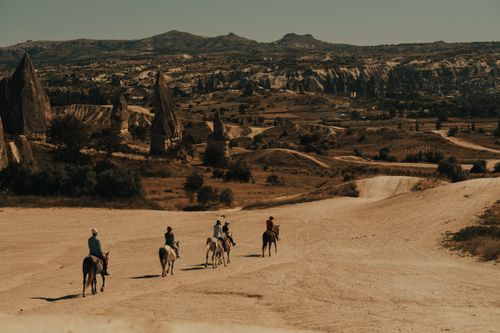 Free A group on horseback explores the stunning landscapes of Cappadocia. Stock Photo