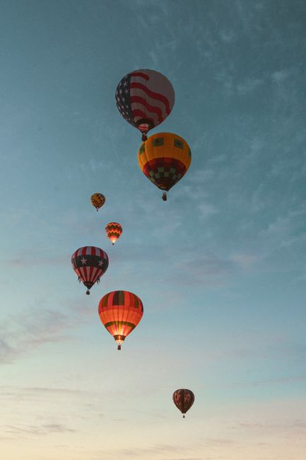 Hot air balloons flying in Reno, Nevada against a serene sky.