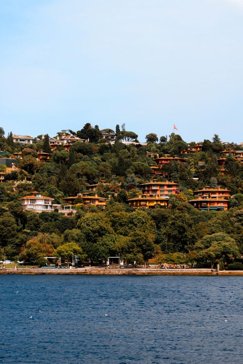 Free Explore the picturesque Bosphorus waterfront with lush green hills and vibrant architecture. Stock Photo