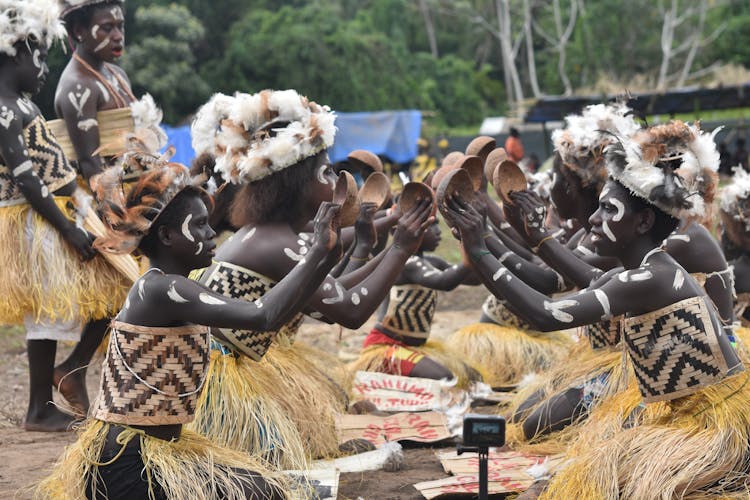 Tribe In Traditional Clothing And Body Paint Dancing 