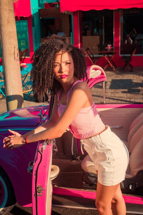 Beautiful Woman Posing beside a Pink Car