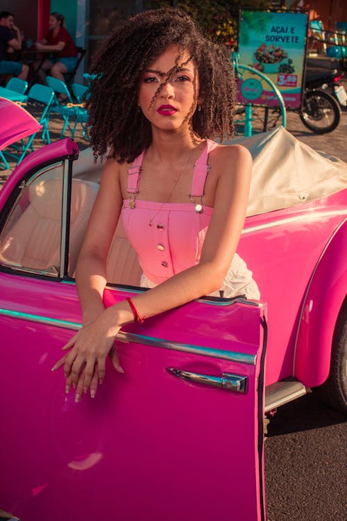 Beautiful Woman Posing on a Pink Car