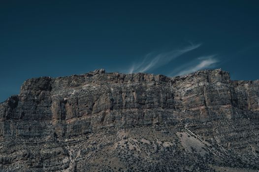 Dramatic rock formations against a vast blue sky, showcasing unique geological features.