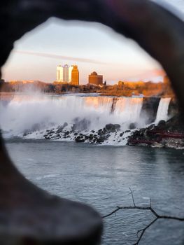 Captivating dawn view of Niagara Falls framed beautifully with city skyline and waterfall.