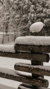 A close-up of snow-covered wooden fence, capturing the essence of a serene winter scene.