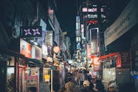 首尔西京洞繁华的夜市街上，霓虹灯闪烁，人群熙攘