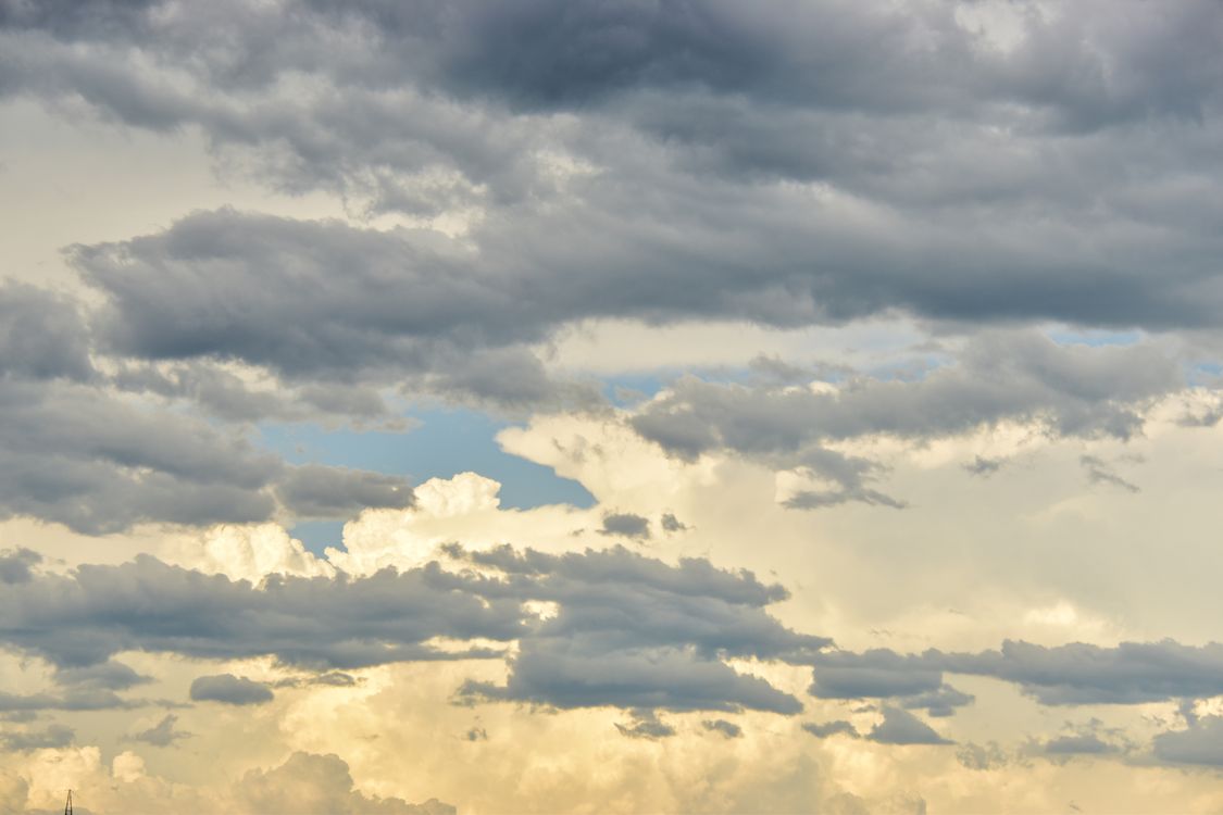 Free A serene cloudscape featuring dramatic clouds and soft sunlight, perfect for backgrounds. Stock Photo