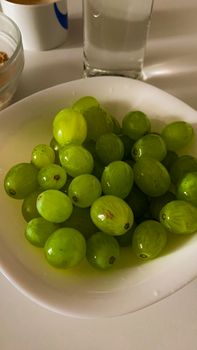 Delicious fresh green grapes in a white bowl, ideal for healthy eating and food photography.