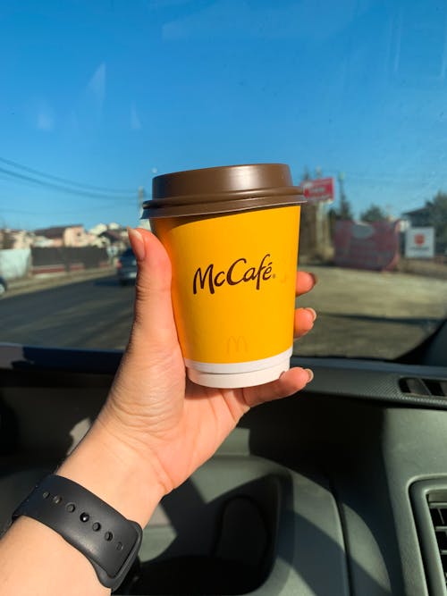 Free A Person's Hand Holding a Coffee Cup Stock Photo