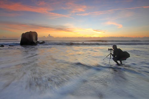 Hombre Tomando Una Fotografía Del Océano En El Cuerpo De Agua Durante La Hora Dorada