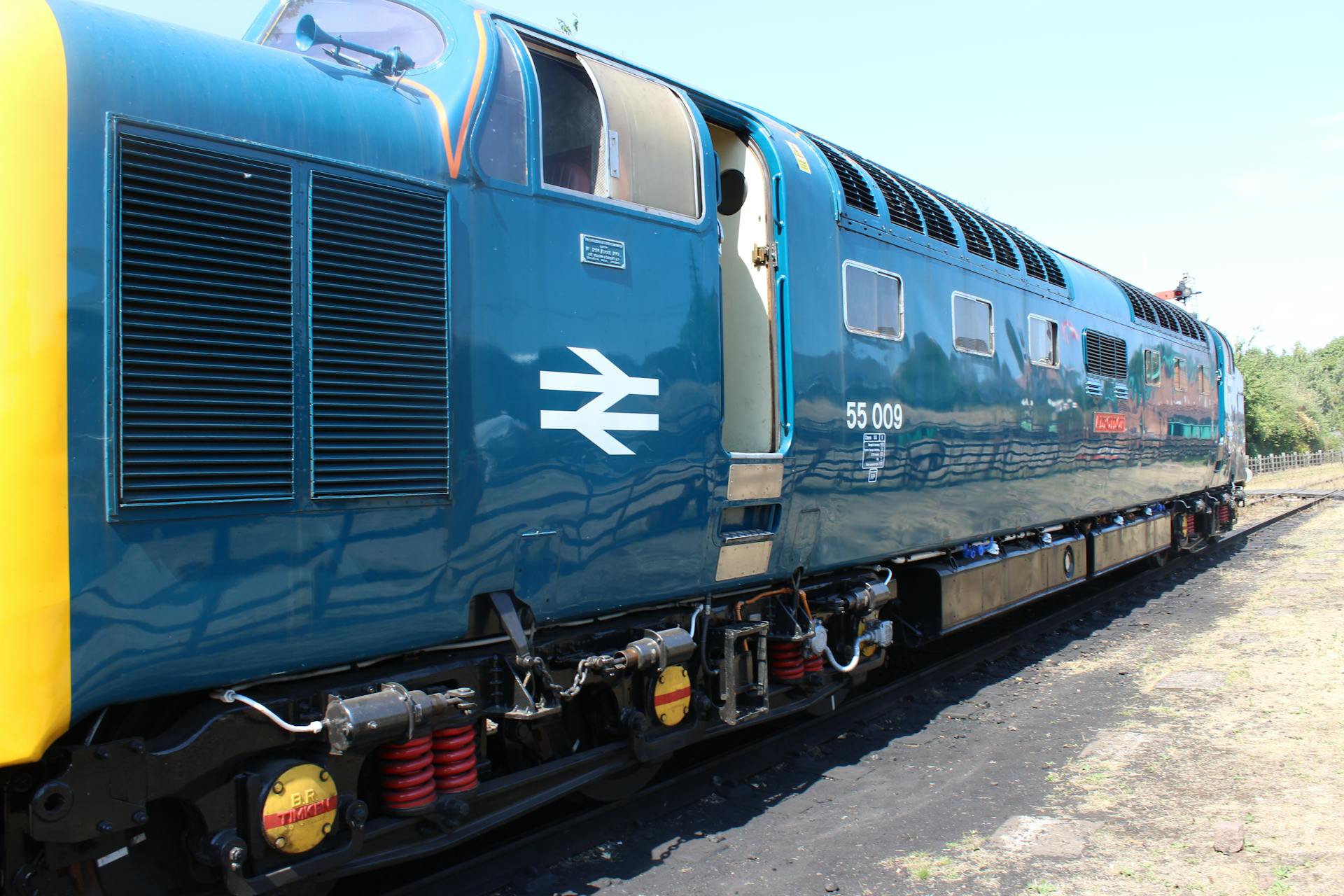 A classic blue diesel locomotive parked at Loughborough station in England, featuring iconic rail designs.