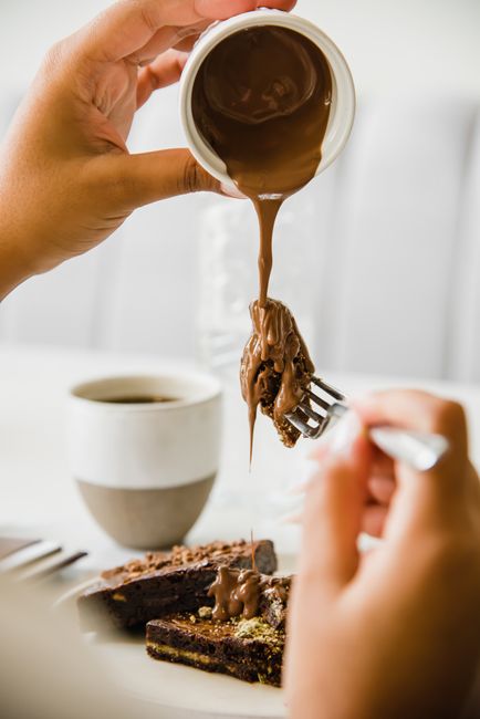 Close-up of a chocolate brownie drizzled with sauce, perfect for dessert lovers.