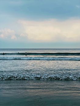 Peaceful beach scene with gentle waves and a calming sky at dusk.