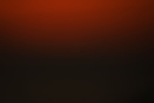 Abstract red and black gradient background with ample copy space.