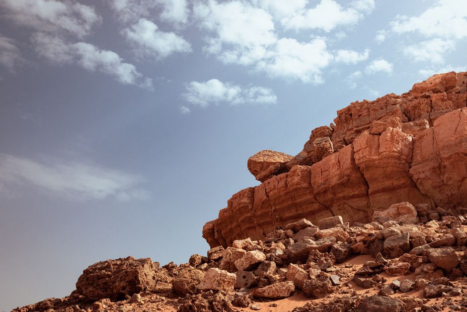 Explore the rugged beauty of Timekten's desert landscape with eroded rock formations under a clear sky.