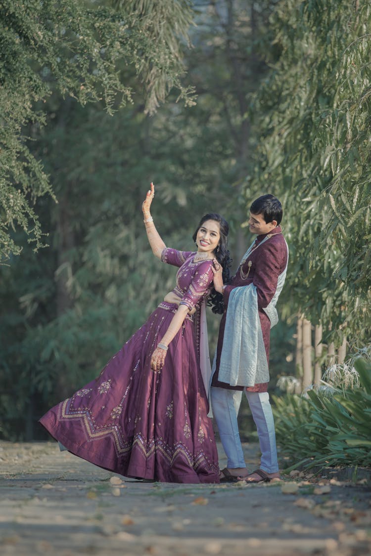 Bride And Groom In Traditional Costumes Dancing In Park