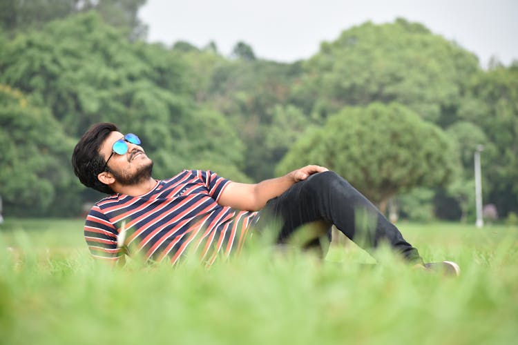 Man Lying On Grass Field