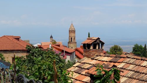 Free Charming town with historic bell tower and traditional rooftops under a clear sky. Stock Photo