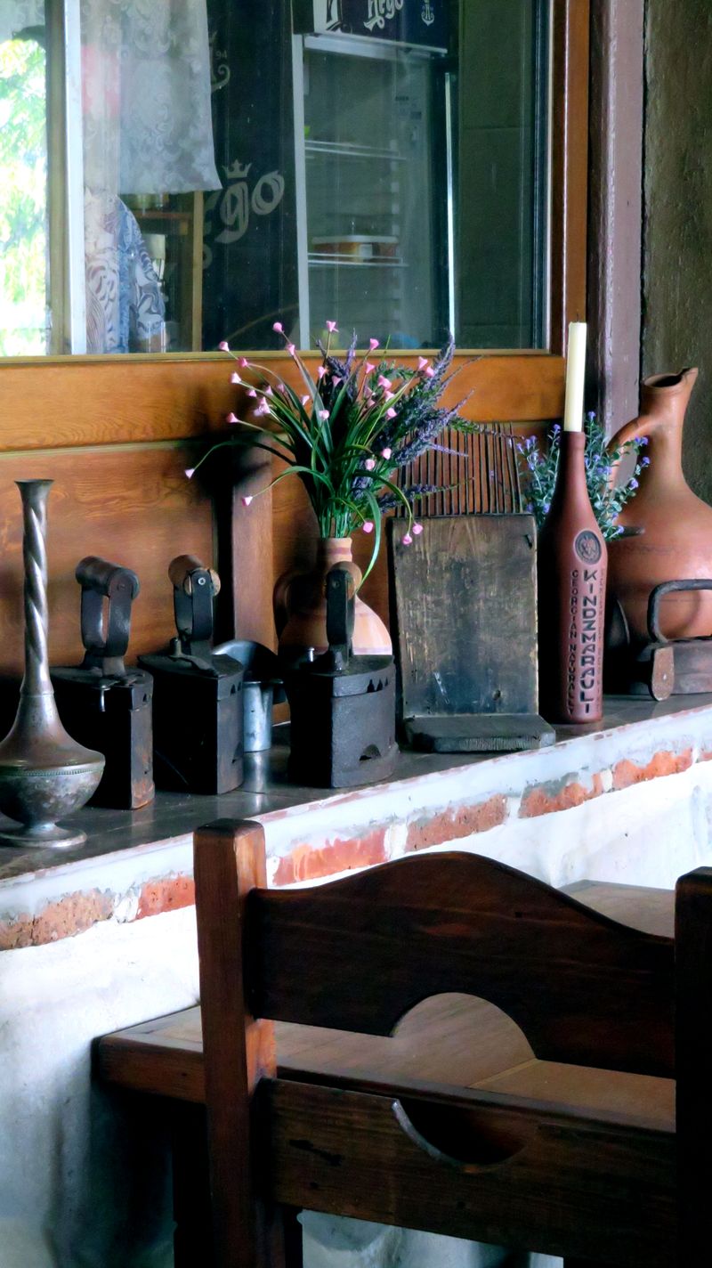 Antique flat irons and vases on a shelf