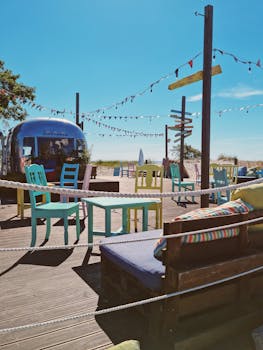Vibrant beachside terrace with colorful chairs and tables under a clear blue sky in Pärnu, Estonia.