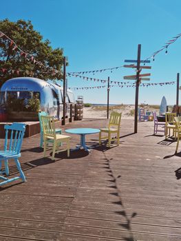 Vibrant chairs and decor on a wooden deck by the beach in Pärnu, Estonia.