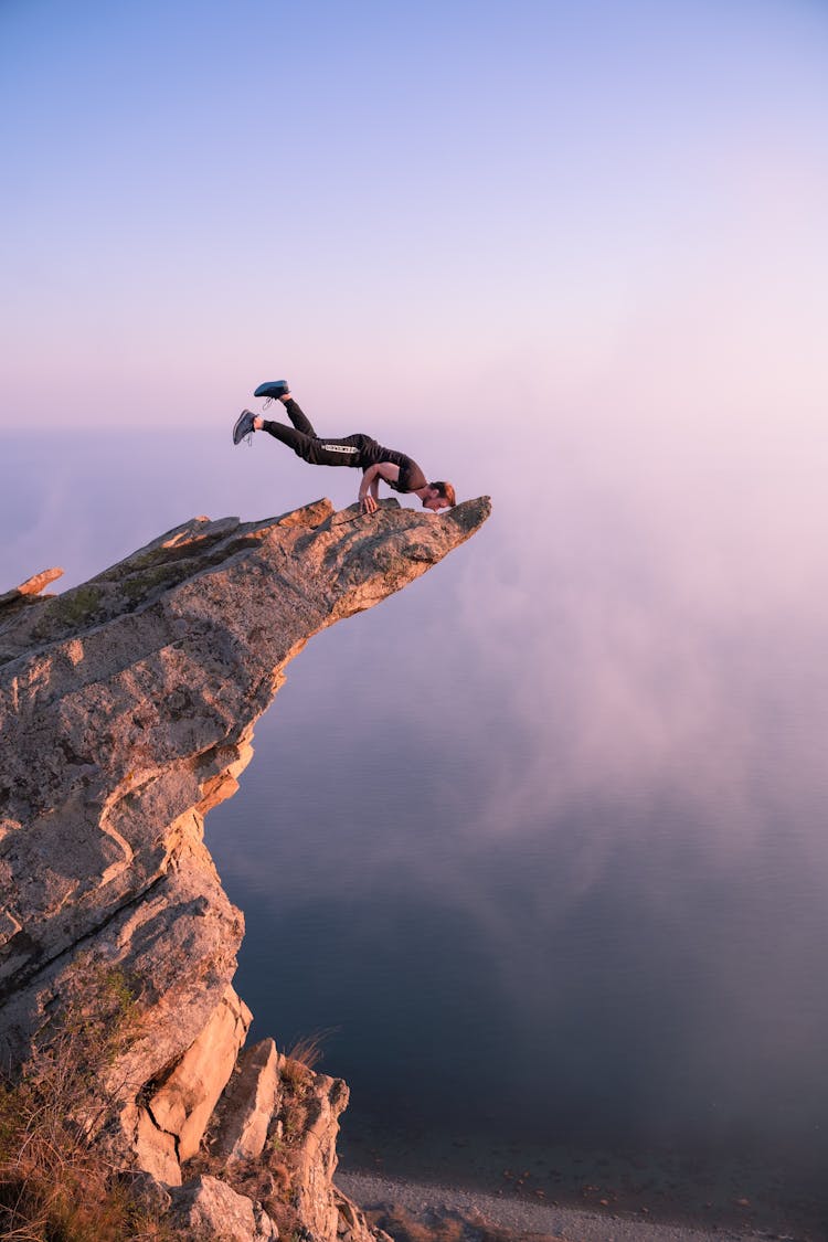 Man Exercising On Top Of Cliff