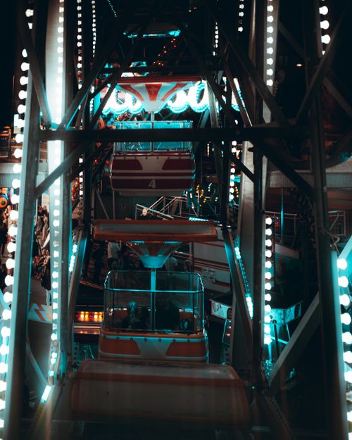 Free Stunning vertical view of an illuminated Ferris wheel at night with vibrant lights. Stock Photo