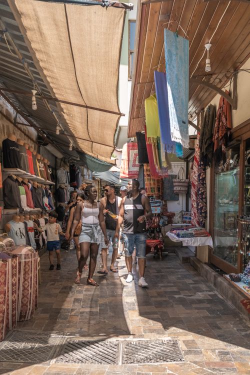 Free Group of tourists explore a lively street bazaar, rich in textiles and souvenirs. Stock Photo