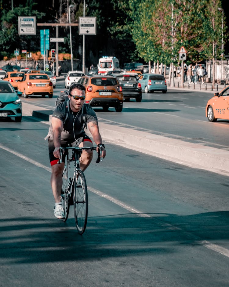 Cyclist On A Busy Street In City 