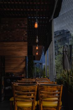 Warmly lit restaurant interior featuring wooden chairs and rustic decor for a cozy dining experience.