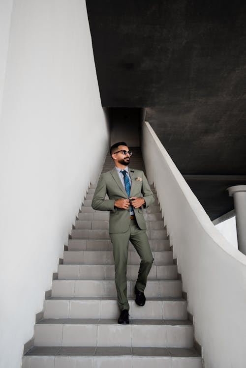 Человек в сером костюме, стоящий на лестнице