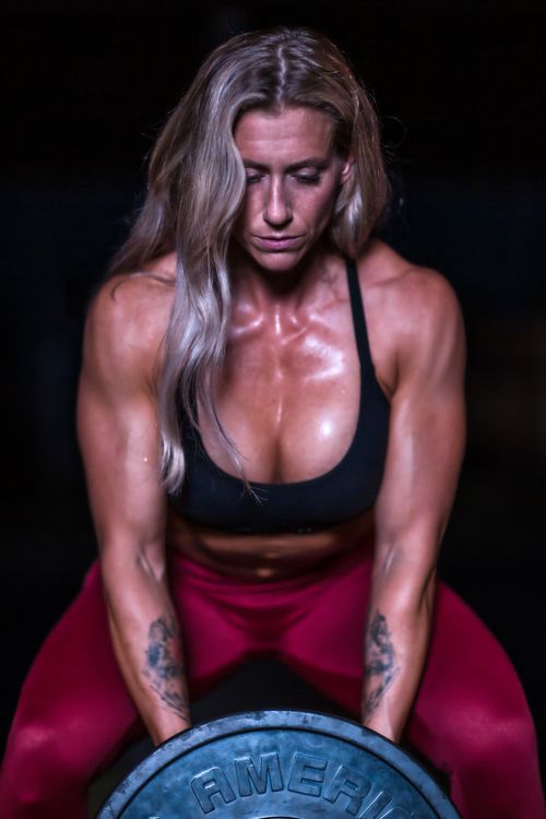Free Focused woman powerlifting, showcasing strength and fitness in a gym setting. Stock Photo