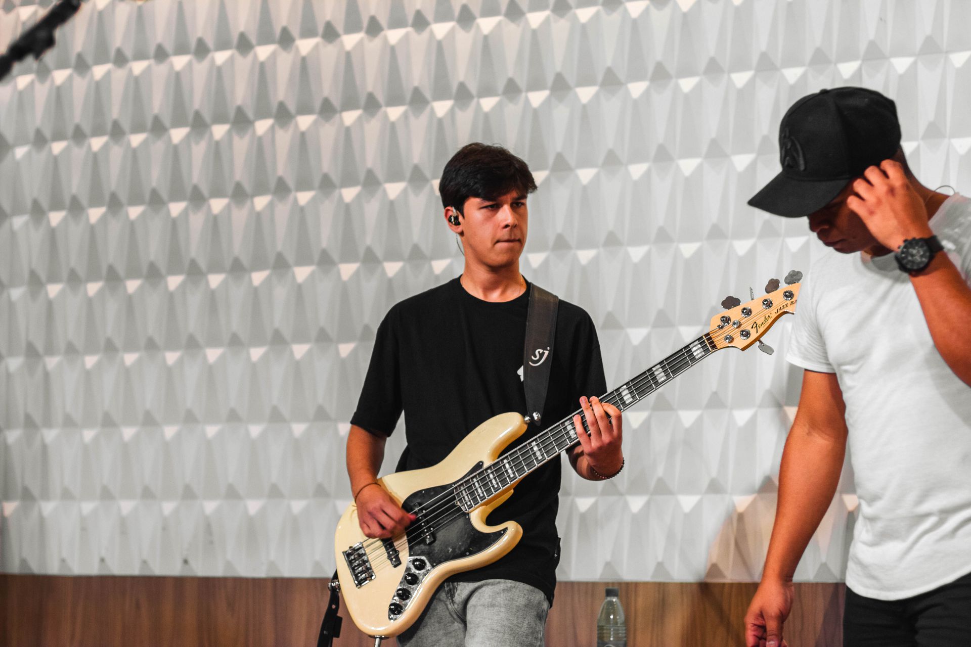 Two musicians rehearsing with electric guitars in a modern studio setting.