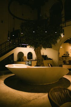 Elegant café interior design in Dubai, featuring a unique tree centerpiece with warm lighting.