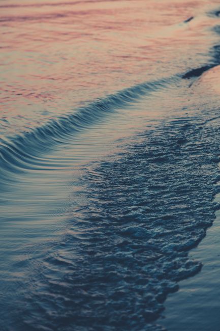 Serene ocean waves gently lapping the shore at sunset, creating a tranquil seascape.