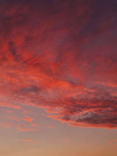 Free A stunning red and pink sunset fills the sky with a dramatic cloudscape. Stock Photo