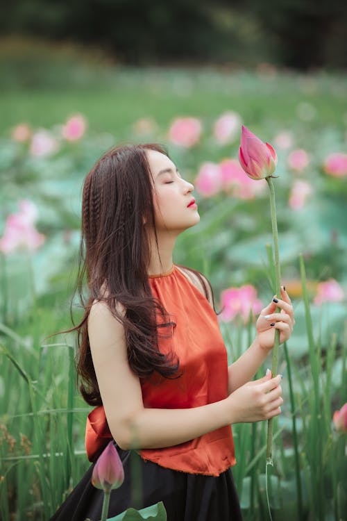 Wanita Memegang Bunga Teratai Merah Muda