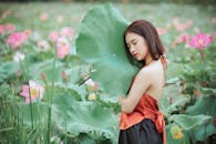 一位年轻女子在充满活力的花田中，拥抱荷叶的宁静肖像