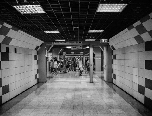 Free A monochrome view of a subway station hallway with people and geometric tile designs. Stock Photo
