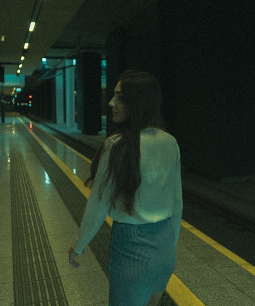 Young Woman Walking on a Platform in a Subway Station