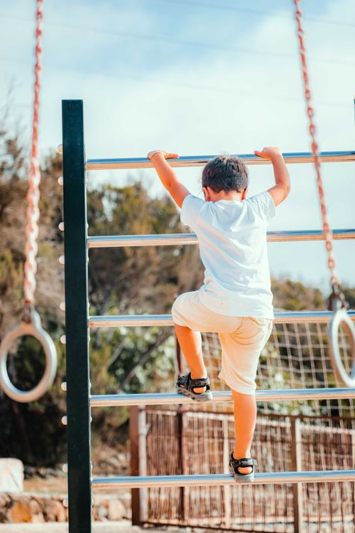 Free Young child climbing on a playground ladder outdoors on a sunny day. Stock Photo